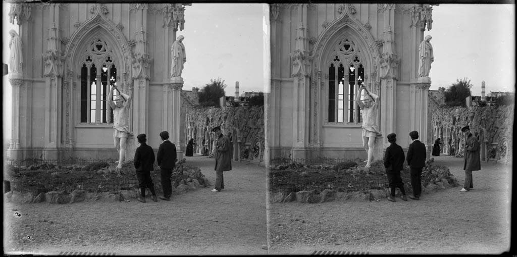 Panteón con una escultura funeraria en el Cementerio del Sudoeste de Barcelona, con varias figuras masculinas en primer plano (finales del siglo XIX).