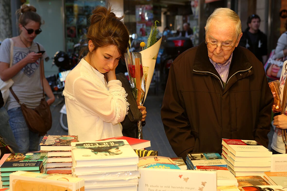 Escena de la festividad de Sant Jordi en Barcelona en 2014, con calles llenas de puestos de libros y flores. La imagen refleja la tradición popular del día de Sant Jordi, cuando la ciudad se convierte en un espacio cultural y festivo dedicado a la literatura y la rosa.