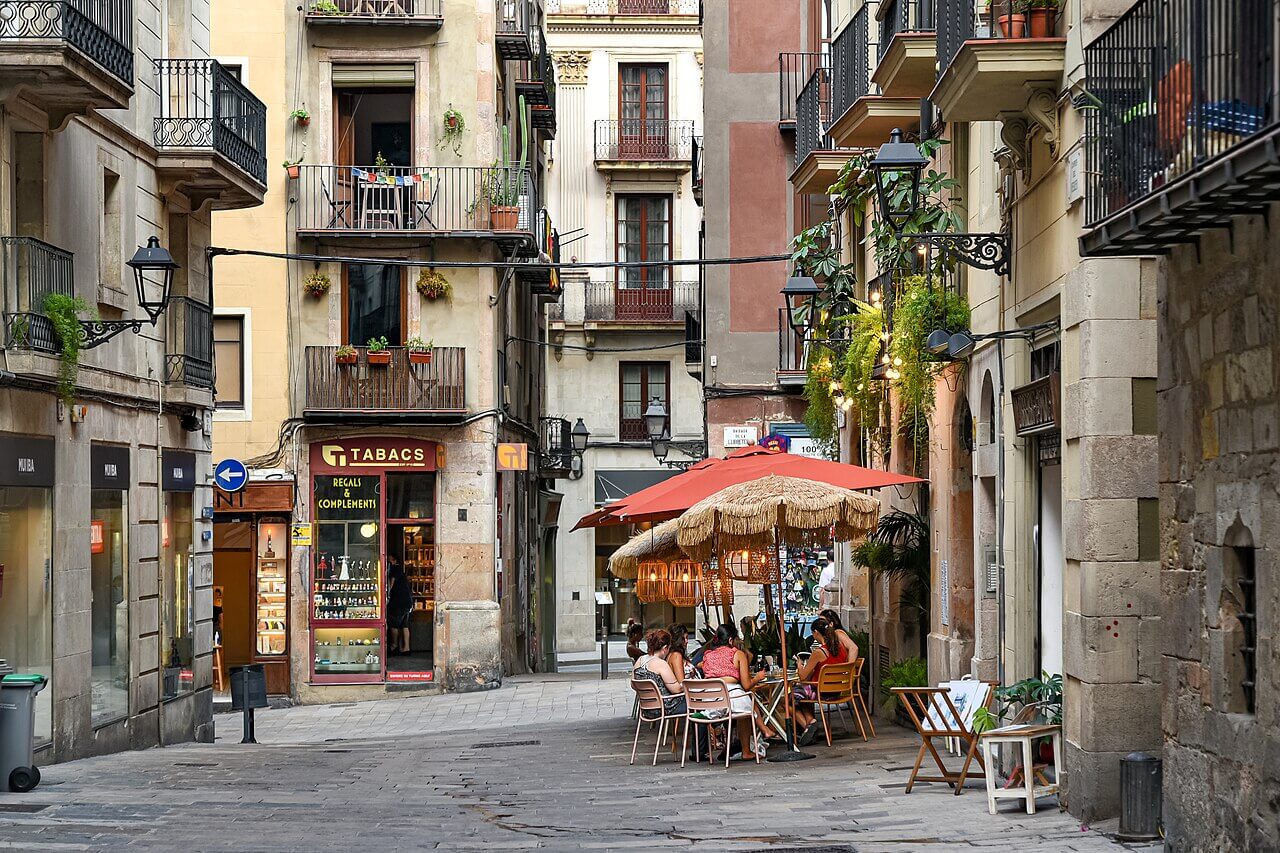 Terraza en la calle del Veguer, en pleno Barrio Gótico de Barcelona, una de las zonas más históricas de Ciutat Vella donde las calles conservan el trazado medieval y la vida cotidiana convive con el turismo.