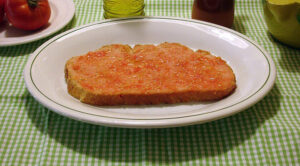 Plato tradicional de la gastronomía catalana, el pa amb tomàquet consiste en pan con tomate, aceite de oliva y sal, uno de los símbolos más simples y representativos de la cocina de Cataluña.