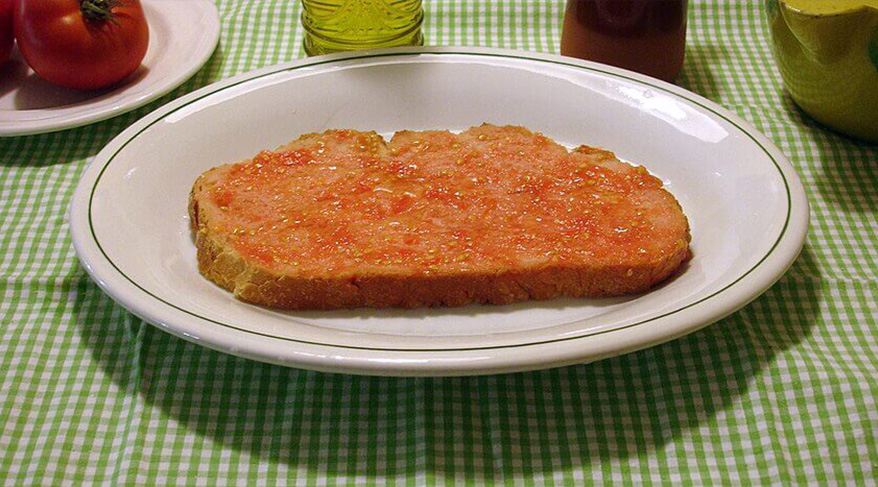 Plato tradicional de la gastronomía catalana, el pa amb tomàquet consiste en pan con tomate, aceite de oliva y sal, uno de los símbolos más simples y representativos de la cocina de Cataluña.
