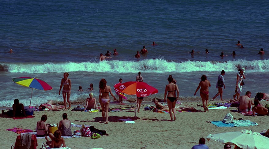 Playa de Barcelona con arena, mar y edificios urbanos al fondo en un día soleado